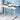 White office desk with a laptop, mug, and plant against a blue wall.