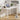 White desk with laptop, lamp, and plant in a room setting