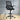 Black office chair with mesh backrest on a wooden floor.