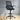 Black office chair with mesh backrest on a wooden floor.