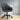 Gray office chair with black wheels on a wooden floor against a gray wall.