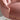 Close-up of a pink velvet chair with gold studs on a neutral background