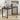 Black desk with laptop, lamp, and plant in a room setting